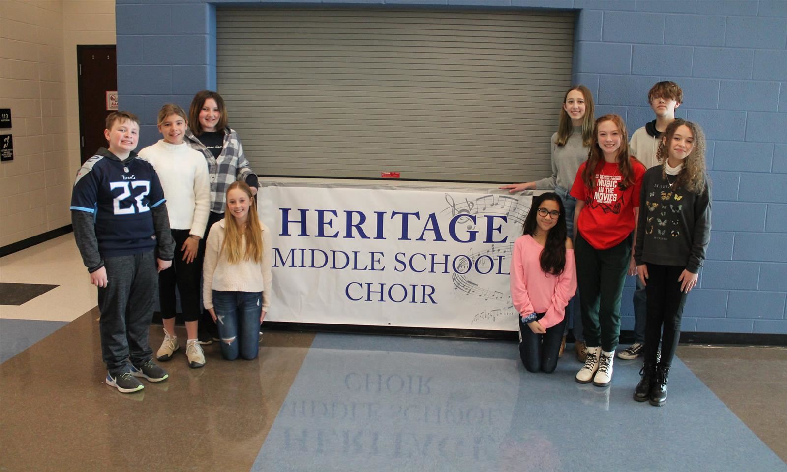 Students hold a banner reading Heritage Middle School Choir